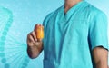 Male doctor holding pill bottle on color background. Medical object Royalty Free Stock Photo