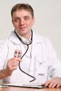 Male doctor holding a pill on white background Royalty Free Stock Photo