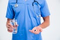 Male doctor holding pills and glass with water Royalty Free Stock Photo