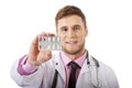 Male doctor holding pills.