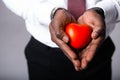 Male doctor holding a red heart in his hands. Cardiology concept Royalty Free Stock Photo