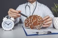 Male doctor holding wooden brain. The importance of early diagnosis concept