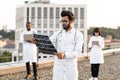 Male doctor holding x-ray scan of patient during break outdoors hospital. Royalty Free Stock Photo