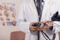 A male doctor holds a blood pressure cuff in his hands.