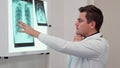 Male doctor holds his hand on the x-ray image