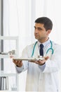 Male doctor hooked up a stethoscope, raised the medicine tray with both hands, held to the front Royalty Free Stock Photo