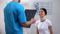 Male doctor informing female patient in foam cervical collar good x-ray result