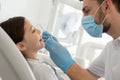 Male doctor with instruments in the hands with girl sitting in the dental chair Royalty Free Stock Photo