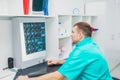 Male doctor looking at x-ray image of cervical spine in his office. Osteopathy, chiropractic, physiotherapy. Healthcare, roentgen,