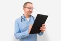 Male doctor making notes on a clipboard on a gray studio background. Health care and medicine Royalty Free Stock Photo