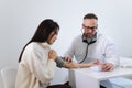 Male doctor at the medical examination measures the blood pressure of a woman patient. Royalty Free Stock Photo