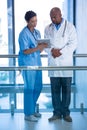 Male doctor and nurse using digital tablet in corridor Royalty Free Stock Photo