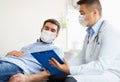 Male doctor and patient in masks at hospital Royalty Free Stock Photo