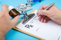 Male doctor or pharmacist holding jar or bottle of pills in hand and writing prescription on a special form. medical Royalty Free Stock Photo