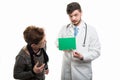 Male doctor pointing on green board to female senior patient Royalty Free Stock Photo