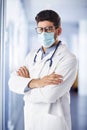 Male doctor portrait while wearing face mask and standing at hospital`s foyer Royalty Free Stock Photo