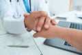 Friendly male doctor`s hands holding female patient`s hand for encouragement and empathy. Partnership, trust and medical Royalty Free Stock Photo