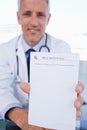 A male doctor showing a blank prescription sheet