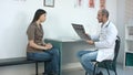 Male doctor showing brain xray results to young woman patient Royalty Free Stock Photo