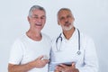 Male doctor showing medical reports to senior man on digital tablet Royalty Free Stock Photo