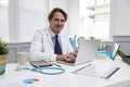 Male Doctor Sitting At Desk Working At Laptop In Office Royalty Free Stock Photo