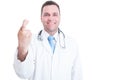 Male doctor smiling and showing fingers crossed with one hand