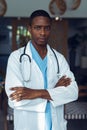 Male doctor standing with arms crossed in the lobby at hospital Royalty Free Stock Photo