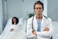 Male doctor standing with arms crossed in the ward at hospital Royalty Free Stock Photo