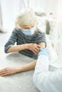 Old woman receiving injection of coronavirus vaccine in clinic Royalty Free Stock Photo