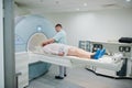 Male doctor turns on magnetic resonance imaging machine with patient inside Royalty Free Stock Photo