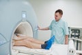 Male doctor turns on magnetic resonance imaging machine with patient inside Royalty Free Stock Photo