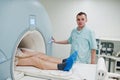 Male doctor turns on magnetic resonance imaging machine with patient inside Royalty Free Stock Photo