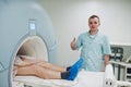 Male doctor turns on magnetic resonance imaging machine with patient inside Royalty Free Stock Photo