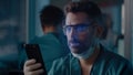 Male doctor unlocking smartphone with face scan