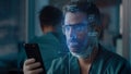 Male doctor unlocking smartphone with face scan