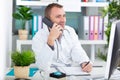 male doctor using computer and telephone at medical office Royalty Free Stock Photo