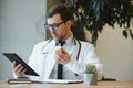 male doctor using tablet computer at his office. General practitioner using digital tablet at his clinic. Royalty Free Stock Photo