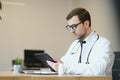 male doctor using tablet computer at his office. General practitioner using digital tablet at his clinic. Royalty Free Stock Photo