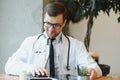 male doctor using tablet computer at his office. General practitioner using digital tablet at his clinic. Royalty Free Stock Photo