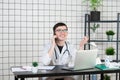 Male doctor using telephone while working on computer at table in clinic Royalty Free Stock Photo
