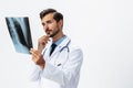 Male doctor in white coat and eyeglasses and stethoscope looking at patient X-rays for diagnosis on white isolated Royalty Free Stock Photo