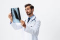 Male doctor in white coat and eyeglasses and stethoscope looking at patient X-rays for diagnosis on white Royalty Free Stock Photo