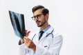 Male doctor in white coat and eyeglasses and stethoscope looking at patient X-rays for diagnosis on white isolated Royalty Free Stock Photo