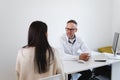 Male doctor in white labcoat talking to female patient in his office. Royalty Free Stock Photo