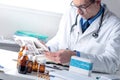 Male Doctor working at his Office Desktop, examining Medical Rep Royalty Free Stock Photo