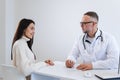 Male doctor writing a prescription for her patient. Physician consulting a young woman. Royalty Free Stock Photo