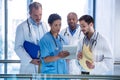 Male doctors and nurse using digital tablet in corridor Royalty Free Stock Photo