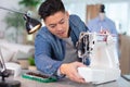 male dressmaker repairing sewing machine