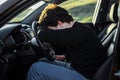 a young man is tired on the road and sleeps on the steering wheel of a car Royalty Free Stock Photo