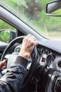 The male driver drives the car, close up view at arms on steering wheel Royalty Free Stock Photo